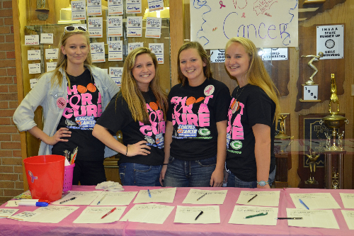 Several students and an adult mentor prepare for 'Coaches vs. Cancer' activities at a game between Greenwood and host Columbus North on Dec. 6, 2016.