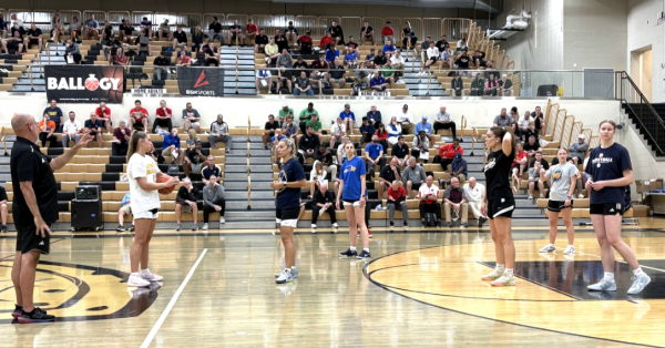 FROM 2025:  Matt Bollant of Bryan College (Tenn.), in black shirt and shorts at left edge of photo, provides instruction on the Buzz Defense during the 2025 IBCA Clinic at Mt. Vernon High School.